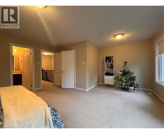 A bedroom with a bed, a dresser, and a window.