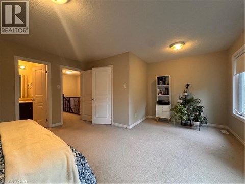 A bedroom with a bed, a dresser, and a window.