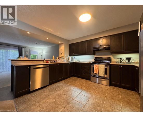 A kitchen with dark wood cabinets and a tile floor.