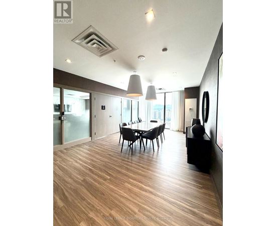 A modern dining room with wooden floors and a glass table.