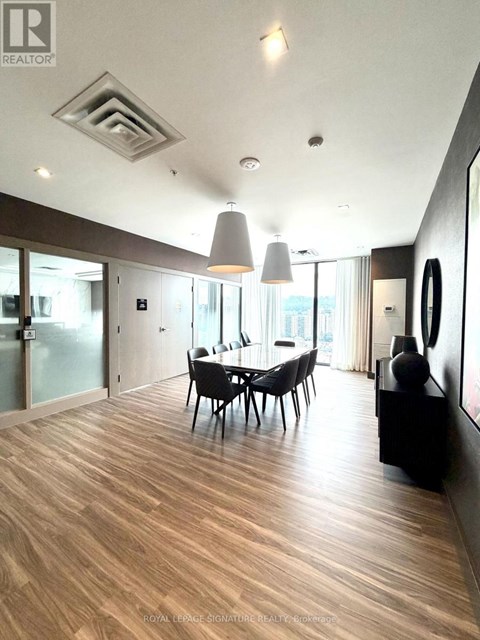 A modern dining room with wooden floors and a glass table.