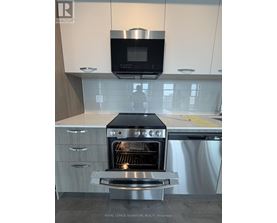 A modern kitchen with a stainless steel oven and microwave above it.