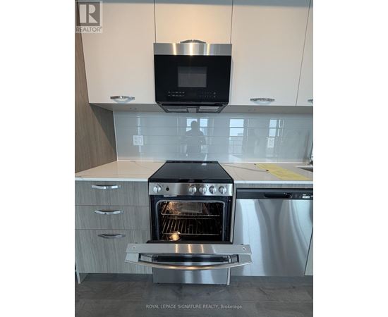 A modern kitchen with a stainless steel oven and microwave above it.