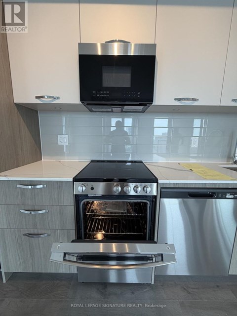 A modern kitchen with a stainless steel oven and microwave above it.