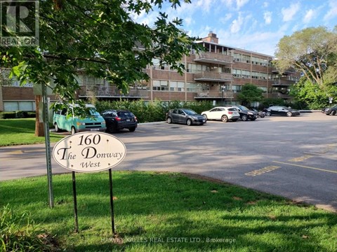A parking lot with cars and a sign that says "160 The Donway West".