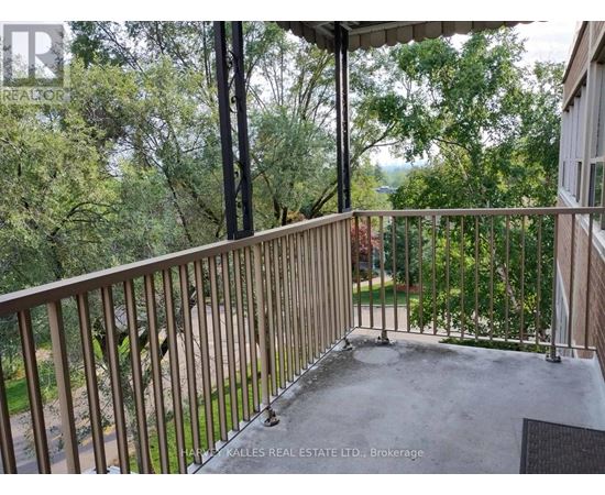 A balcony with a metal railing and a view of trees.