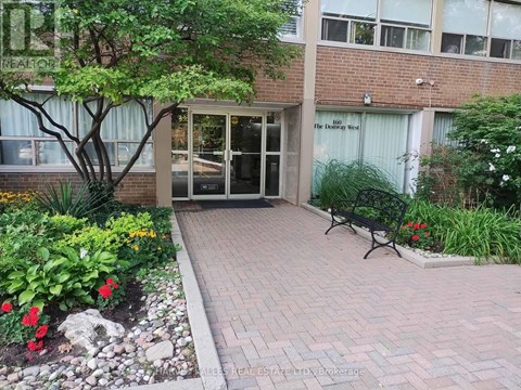 A brick walkway leads to a glass door entrance.