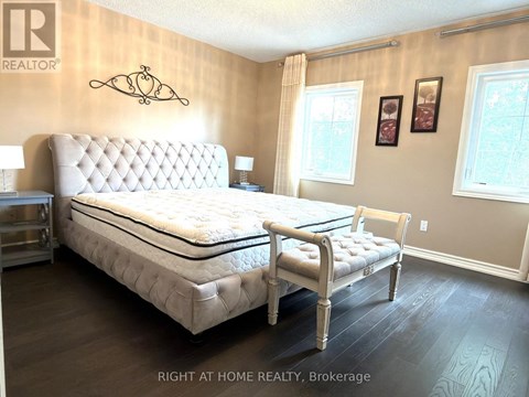 A bedroom with a large bed and a bench.
