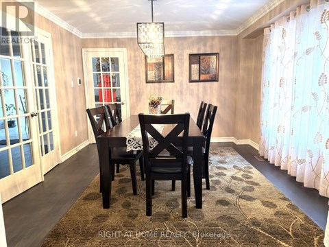 A dining room with a table and chairs.