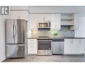 A modern kitchen with a stainless steel refrigerator and oven.