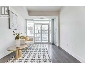 A hallway with a patterned floor and a table with a vase of flowers on it.