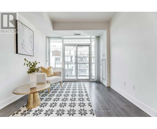 A hallway with a patterned floor and a table with a vase of flowers on it.