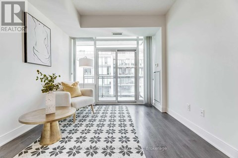 A hallway with a patterned floor and a table with a vase of flowers on it.