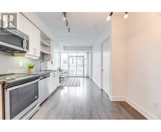 A modern kitchen with white cabinets and a stainless steel oven.