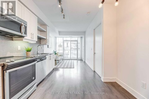 A modern kitchen with white cabinets and a stainless steel oven.