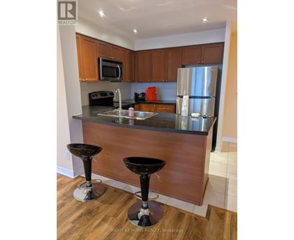 A kitchen with a black counter top and two black stools.