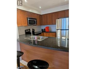 A kitchen with wooden cabinets and a granite countertop.
