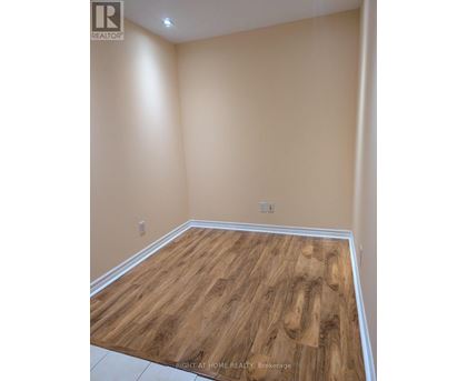 A room with wooden flooring and beige walls.