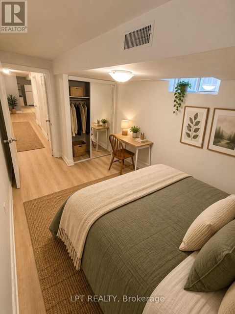 A bedroom with a bed, desk, and closet.
