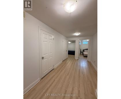 A hallway with wood floors and white walls.
