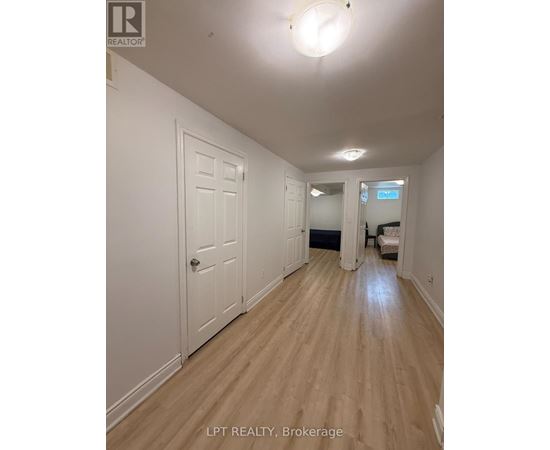 A hallway with wood floors and white walls.
