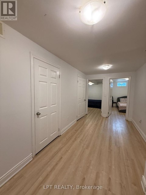 A hallway with wood floors and white walls.