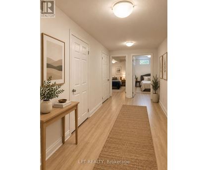 A hallway with a brown rug and a wooden table with a plant on it.