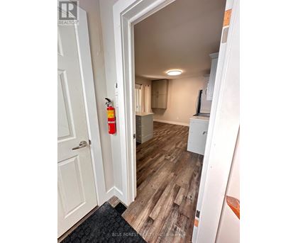 A hallway with a white door and a red fire extinguisher on the wall.