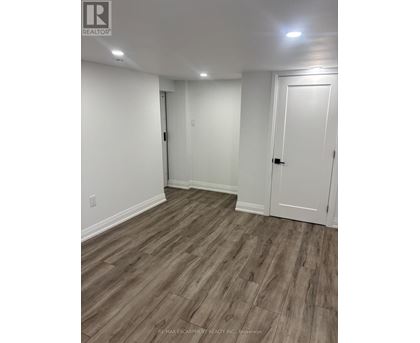 A room with white walls and wood flooring.