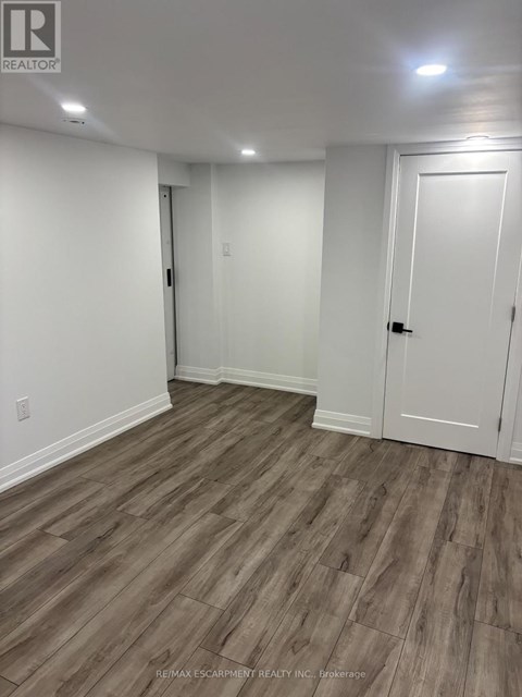A room with white walls and wood flooring.