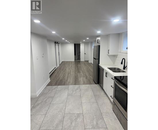 A kitchen with white cabinets and a black stove top oven.