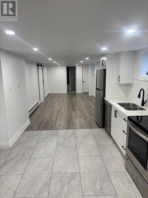 A kitchen with white cabinets and a black stove top oven.