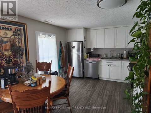 A kitchen with a table and chairs in the foreground.