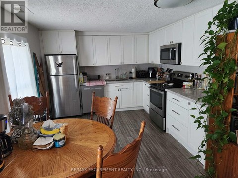 A kitchen with white cabinets and a wooden table.