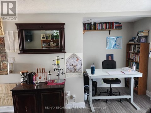 A room with a desk, chair, and a bookshelf filled with books.