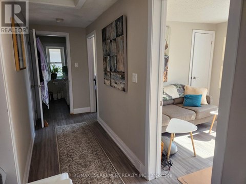 A hallway with a carpeted floor and a painting on the wall.