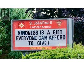 A sign for St. John Paul II Catholic School encourages kindness.