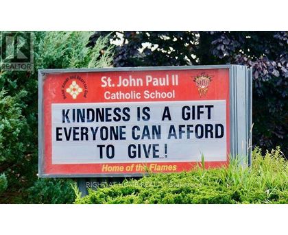 A sign for St. John Paul II Catholic School encourages kindness.
