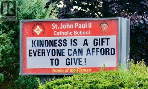 A sign for St. John Paul II Catholic School encourages kindness.