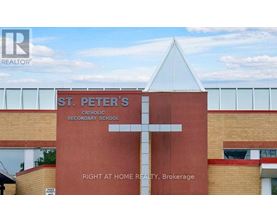 A church with a cross on it and a sign that says St. Peter's Catholic Secondary School.