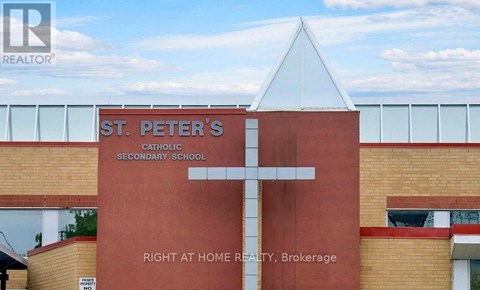 A church with a cross on it and a sign that says St. Peter's Catholic Secondary School.