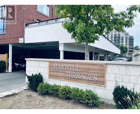 A sign that says Maxwell Terraces in front of a building.
