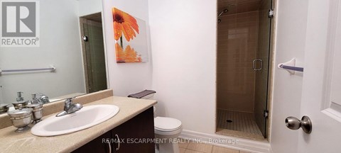 A bathroom with a sink, toilet and shower.