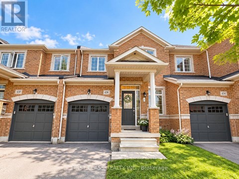 A large, well-maintained house with a brick facade and multiple garage doors.