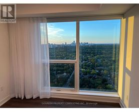 A room with a view of the city through a large window.