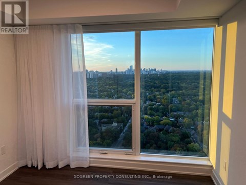 A room with a view of the city through a large window.
