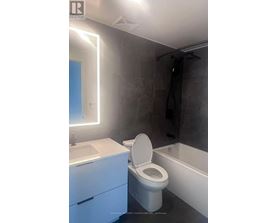 A modern bathroom with a white toilet and a white sink.