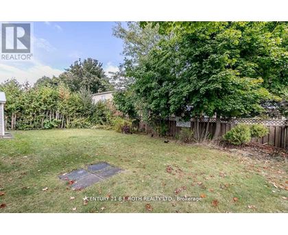 A backyard with a lawn and trees.