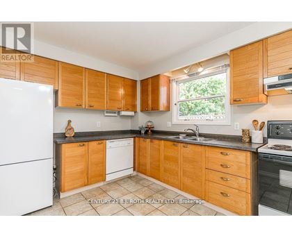 A kitchen with wooden cabinets and a white fridge.