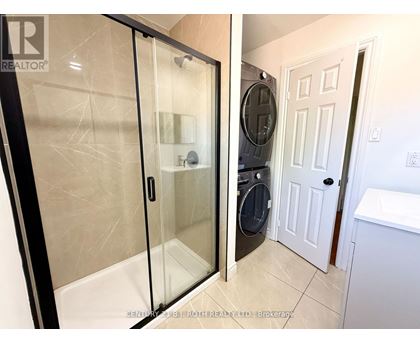 A bathroom with a glass shower door and a white door.